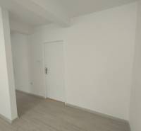 Weiße Wände und Türen in Geschäftsräumen mit Holzboden.