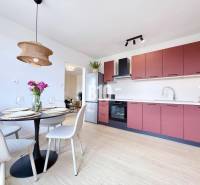 Küche in einer 3-Zimmer-Wohnung mit Esstisch, bunten Schränken und Leuchte.