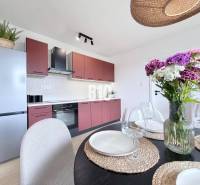 Küche in einer 3-Zimmer-Wohnung mit Tisch, Blumen und moderner Ausstattung.