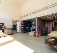 Innenräume von Lagern und Hallen mit Regalen und Arbeitstischen, ausgestattet mit verschiedenen Werkzeugen und Materialien.