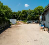 Gepflasterte Fläche bei der Lagerhalle in der Kasárenská-Straße in Trenčín, umgeben von Grünflächen.