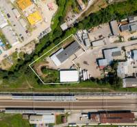 Luftaufnahme von Lagerhäusern und Hallen in Trenčín in der Kasárenská-Straße bei der Eisenbahnstrecke.