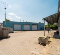 Lager und Hallen in der Kasárenská-Straße in Trenčín mit befestigter Fläche und blauem Gebäude.