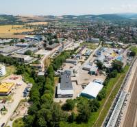 Luftaufnahme des Industriegebiets in der Kasárenská-Straße in Trenčín mit Lagerhäusern und Hallen.