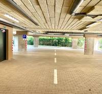 Parkhaus mit barrierefreiem Zugang, beleuchtet und mit markierten Parkplätzen.