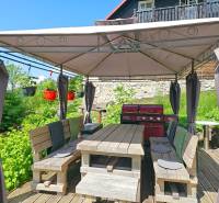 Einfamilienhaus in Donovaly mit Terrasse und Unterstand, neben einer gemauerten Mauer.