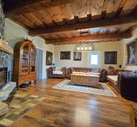 Wohnzimmer in einem Einfamilienhaus mit Kamin, Holzbalkendecke und bequemen Sofas.