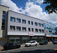 Ein Bürogebäude in der 1. Mai-Straße in Poprad mit geparkten Autos.