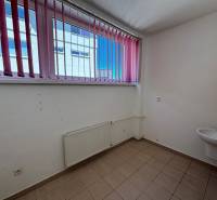 Innenraum eines leeren Ladenlokals mit Fenster und Waschbecken.