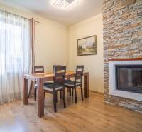 Esszimmer in der Ferienwohnung mit Holztisch und Kamin mit Steinverkleidung.