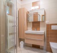 Badezimmer in einer Ferienwohnung mit Holzmöbeln und Duschkabine.