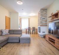 Wohnzimmer in einer Ferienwohnung mit Kamin und bequemer Couch.