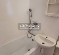 Badezimmer in einer Einzimmerwohnung mit Badewanne, Spiegel und Waschbecken.