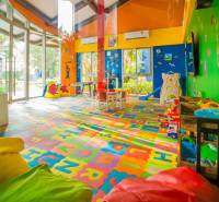Ein farbenfroher Indoor-Spielplatz im Inneren eines Wohnbauprojekts mit Spielzeug und Tischen.
