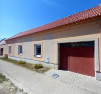 Ein Einfamilienhaus in Trakovice mit einem Schrägdach und zwei Fenstern, die zur Straße zeigen.
