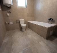 Badezimmer im Einfamilienhaus mit Badewanne, Toilette und Boiler.