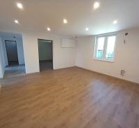 Wohnzimmer in einem Einfamilienhaus mit Holzboden und weißen Wänden.