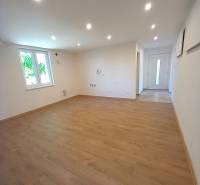 Ein geräumiges Zimmer mit Laminatboden und Spotlichtern in einem Einfamilienhaus.