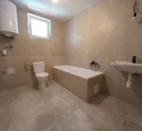 Badezimmer im Einfamilienhaus mit Badewanne, Waschbecken und WC.