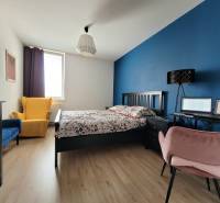 Schlafzimmer in einer 3-Zimmer-Wohnung mit bunten Sesseln und einer Arbeitsecke.