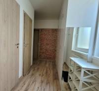 Ein heller Flur mit Holztüren und Ziegeldekor in einer 3-Zimmer-Wohnung.