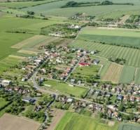Luftaufnahme eines Dorfes zwischen Feldern in Kamenné Kosihy, ideal für Gewerbegrundstücke.