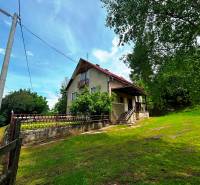 Ein Einfamilienhaus in Veľká Lesná mit einem weitläufigen Hof und Baumbewuchs.