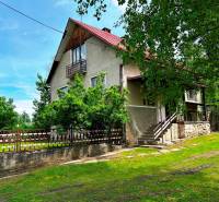 Ein Einfamilienhaus in Veľká Lesná, umgeben von Grün und einem Holzzaun.