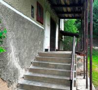 Der Eingang mit Treppe zu einem Einfamilienhaus in Veľká Lesná, umgeben von grüner Vegetation.