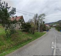 Ein Weg bei einem Einfamilienhaus im Dorf Veľká Lesná, umgeben von Grün und Bäumen.