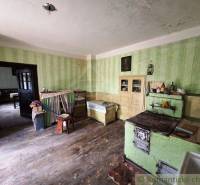 Eine Küche in einem Einfamilienhaus mit antiken Möbeln und einem Herd, sichtbarer Holzboden.