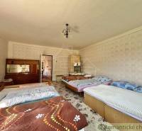 Ein Schlafzimmer in einem Einfamilienhaus mit fünf Betten, einem Schrank und einer dekorativen Tapete.