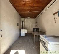 Eine Küche in einem Einfamilienhaus mit einer Holzträgerdecke und einer Wandgarderobe.
