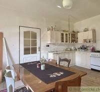Eine Küche in einem Einfamilienhaus mit einem Holztisch und weißen Möbeln.