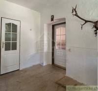 Ein weißes Zimmer mit zwei Türen und einem Geweih in einem Einfamilienhaus.