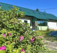 Ein Einfamilienhaus in Spišská Nová Ves mit Grünflächen und rosa Blumen im Garten.