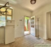 Interieur eines Einfamilienhauses mit antiken Elementen und einfacher Einrichtung.