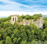 Die Burgruine auf einem Felsen, umgeben von Wäldern in Malacky, schafft eine malerische Gartenszenerie.