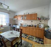 Küche in einem Einfamilienhaus mit Einrichtung, Esstisch und Küchenzeile.