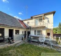 Ein Einfamilienhaus in Sielnica, ein Garten mit Terrasse, ein Wäschetrockner, ein Schaukelstuhl, blauer Himmel.