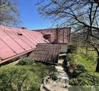 Ein Haus in Rožňava mit einem roten Dach, umgeben von Bäumen und Grün.