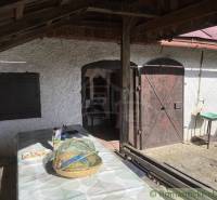 Veranda mit Holztüren bei der Hütte in Rožňava mit einem Tisch und einem Korb.