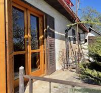 Außenbereich der Hütte mit alten Holztüren und Grün, ideal für besondere Immobilien.