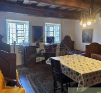 Traditionelles Interieur mit Holzbalken und besonderer Beleuchtung, ergänzt durch antike Möbel.