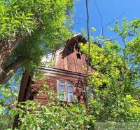 Eine Hütte in Liptovský Mikuláš, umgeben von dichtem Grün unter klarem blauem Himmel.