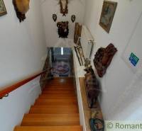 Eine Treppe im Einfamilienhaus, dekoriert mit Jagdtrophäen und Bildern.