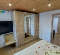 Schlafzimmer mit Holzdecke, Bett und Schränken im Einfamilienhaus.