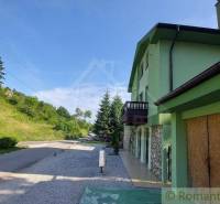 Ein Einfamilienhaus in Dobrá Voda mit einer Straße, umliegender Natur und einer grünen Fassade.