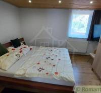 Ein Schlafzimmer in einem Einfamilienhaus mit einem gemütlichen Bett und einer Holzdecke.