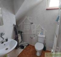 Badezimmer mit Toilette, Waschbecken und Heizkörper im Dachgeschoss eines Einfamilienhauses.